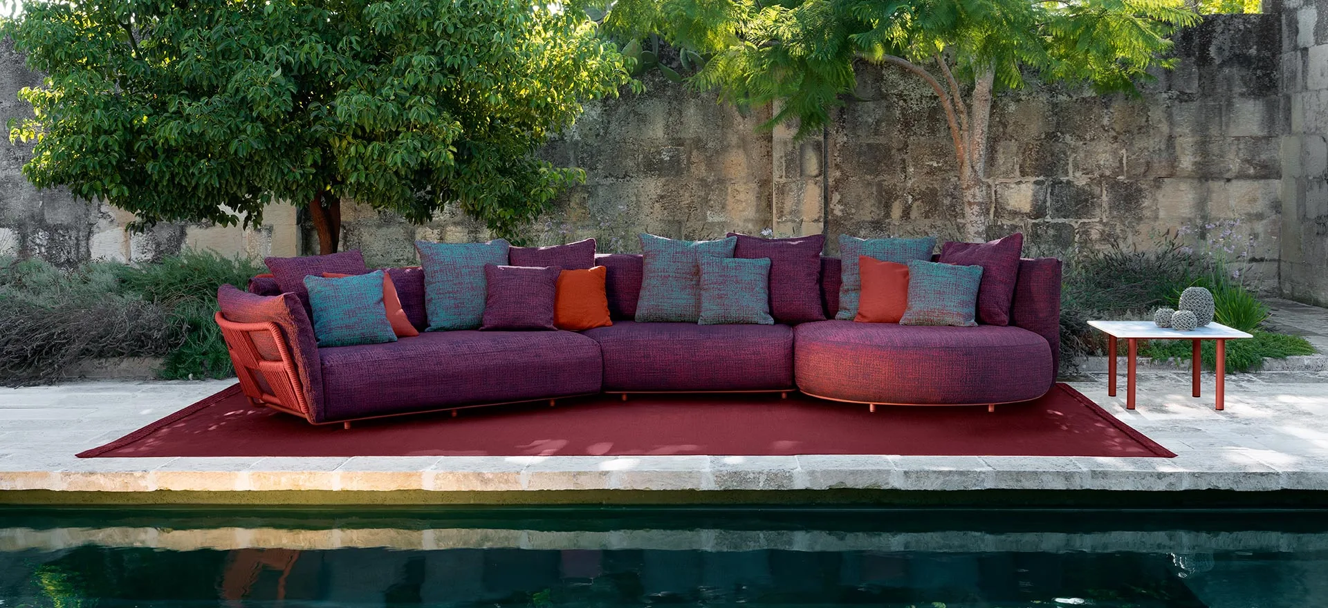 A Talenti Scacco sofa arrangement beside a pool